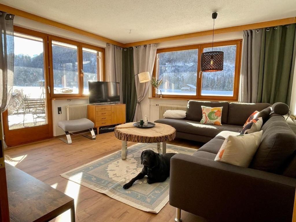 Wohnzimmer der Ferienwohnung in Schruns mit großem Sofa und Bergblick aus den Fenstern