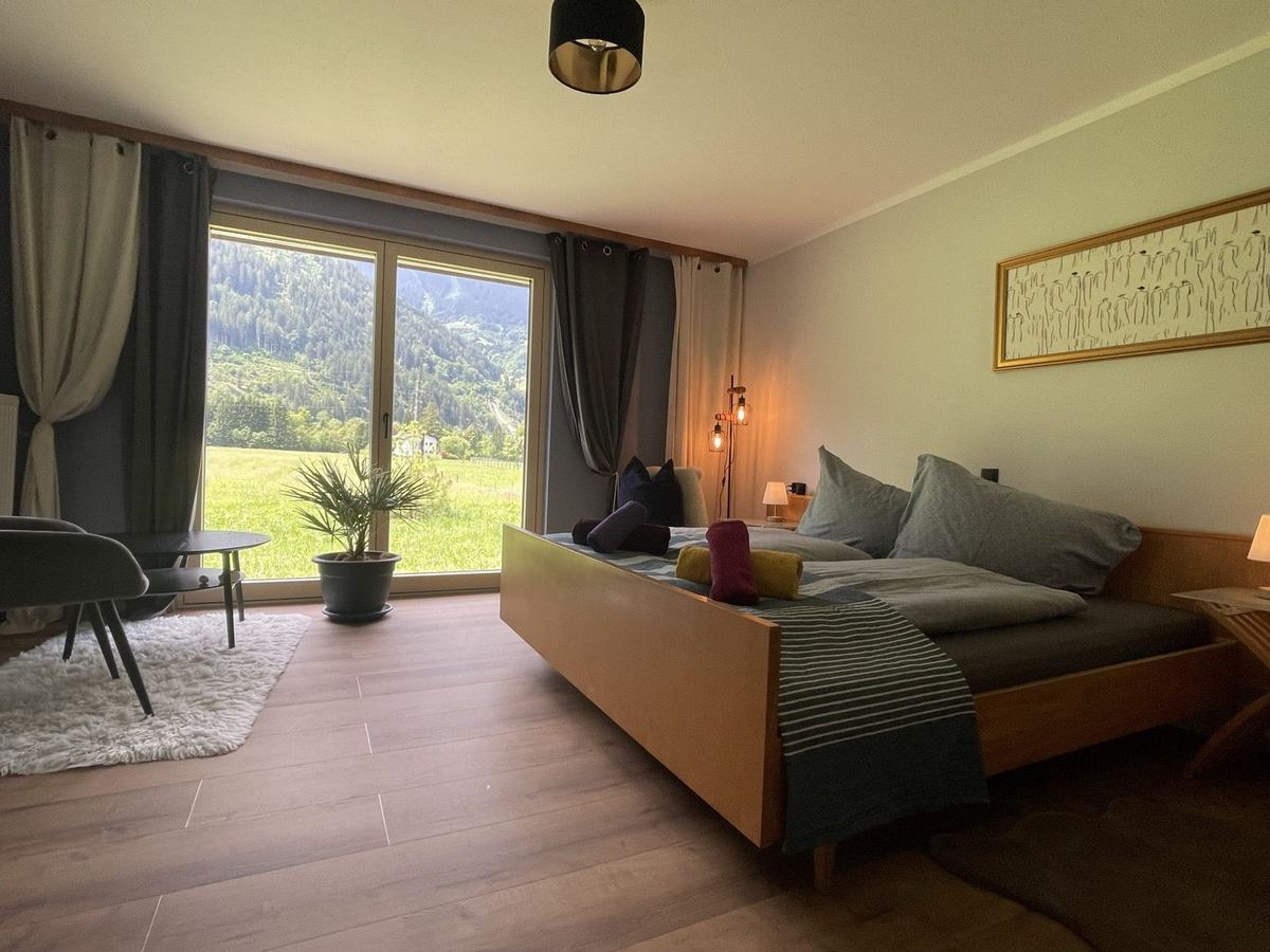 Schlafzimmer mit Doppelbett und bodentiefem Fenster zur Wiese, Ferienwohnung Montafon