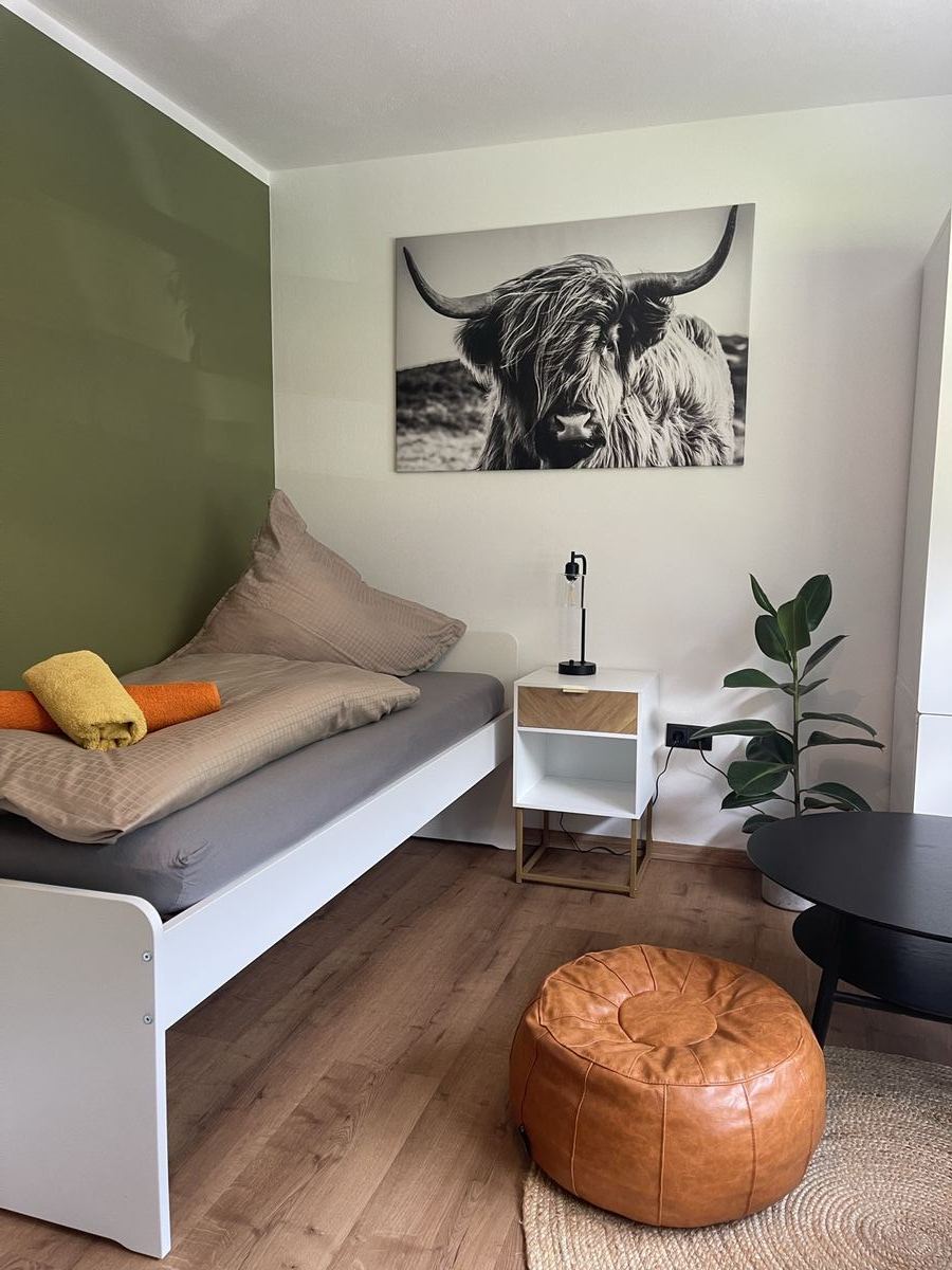 Schlafzimmer mit grüner Wand und Sitzgelegenheit, Ferienwohnung Montafon
